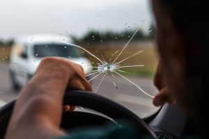 cracked windshield in front of the driver in a car